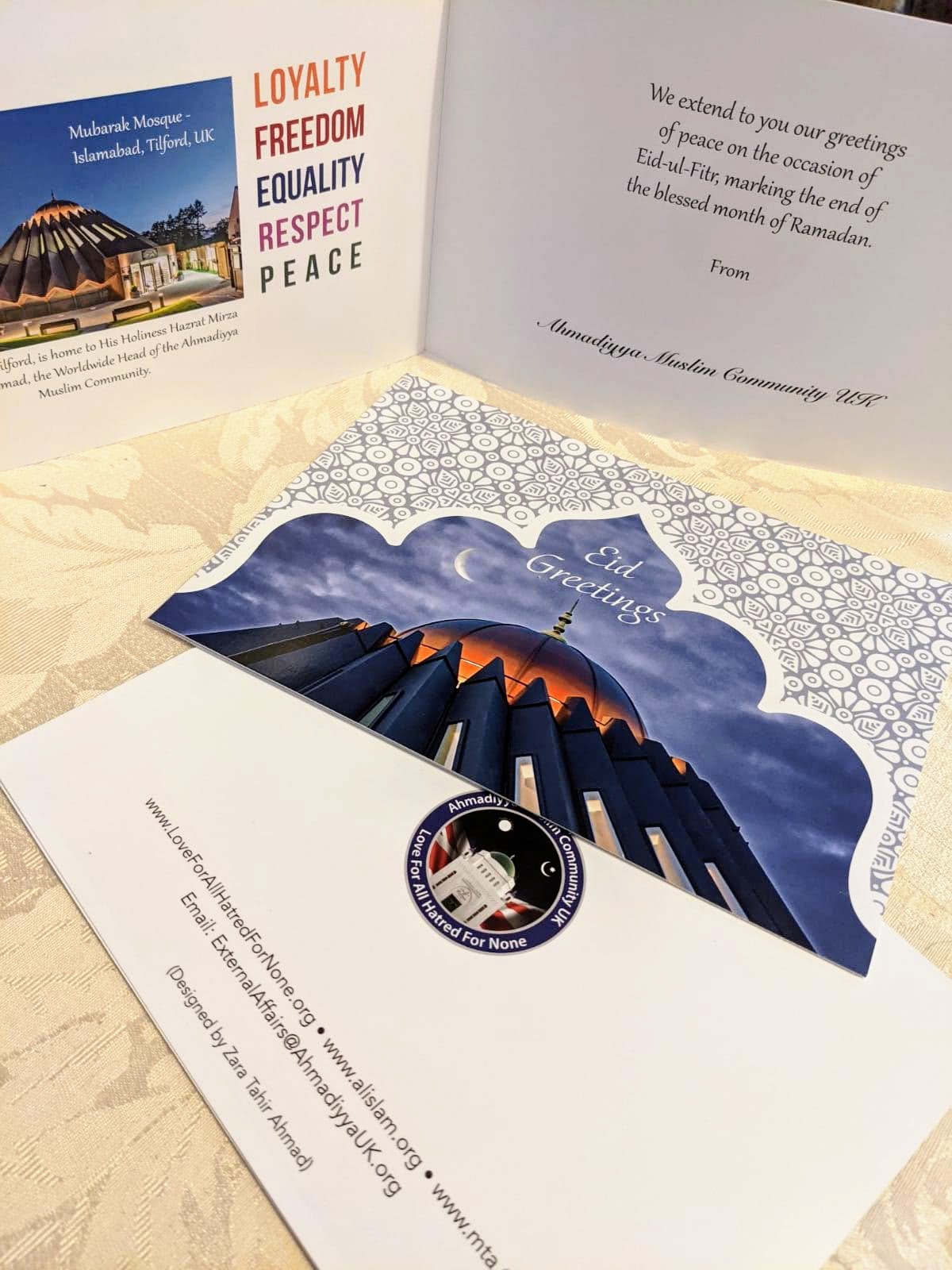 The printed Eid card open on a tablecloth