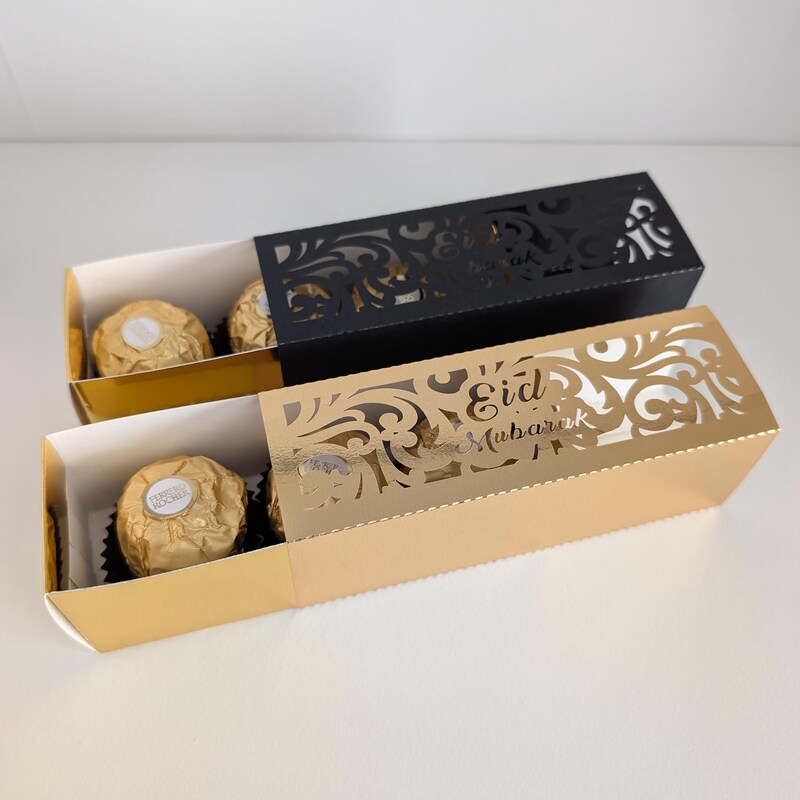 Gold and black laser-cut Eid favour sleeves open to show chocolates inside